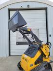 ZJG-380 mini skid steer with the dirt bucket raised on its lift arms, yellow body on rubber tracks