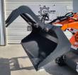 Gray grapple bucket attached to an orange mini skid steer, grapple arm raised open
