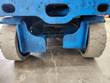 Scissor lift undercarriage close-up, drive wheels and hydraulic lines