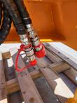 Post driver's two hydraulic hoses with quick-connect couplers and a red dust cap