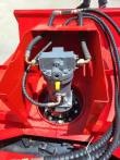 Direct-drive hydraulic motor bolted in the mulcher housing, sleeved hoses and elbow fittings on the ports