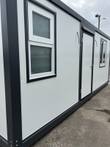 Portable office exterior in white insulated panels, steel entry door and stacked sliding windows
