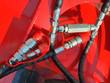 Disc mulcher hydraulic hookup: chrome quick-connect couplers with red caps and a flow valve on red housing