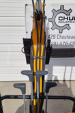MIVA VA15 operator's view: four T-handle travel and blade levers with the yellow boom and hoses ahead