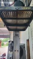 Underside of the JLG 12SP platform: JLG 12SP badge and perforated steel deck with the mast below
