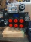 Hydraulic control valve, black body, six red-capped work ports and joystick linkage bracket