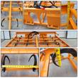 Landhonor hay accumulator: orange steel grid frame with curved black spring hooks, hydraulic hose and quick-attach mount