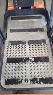 JLG 12SP platform deck: perforated steel floor with worn black anti-slip strips