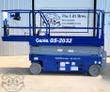 Blue Genie GS-2032 scissor lift, guardrails up and control box on the rail, platform fully lowered on the scissor stack