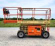 JLG 260MRT rough-terrain scissor lift on lugged tires, platform lowered with the slide-out deck extended