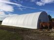 White PVC fabric storage building, arched roof with a walk-in door at the gable end