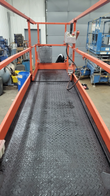 Scissor lift platform deck, diamond-plate flooring, toward the controls