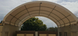 Container shelter's arched fabric roof on galvanized purlins, open at both ends between two containers