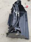 Black 4-in-1 skid steer bucket from above: mount plate, cylinder, braided hoses and red-capped coupler