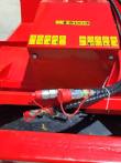 Disc mulcher motor cover with yellow safety decals, hydraulic couplers capped in red below