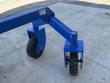 Blue dozer blade's cutting edge with rubber wear strip and caution/warning safety labels