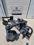 Harley power rake on the shop floor: caster gauge wheels, leveling drum and skid steer frame