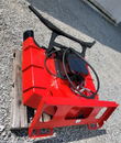 Red disc mulcher on a pallet, angled top view: quick-attach mount plate, hydraulic motor and coiled hoses