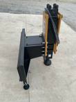 AGROTK 750 post driver resting on its quick-attach plate, yellow mount rails, hydraulic port block and domed driving cup