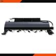 Wolverine skid steer tiller: curved tines under a gray hood, end skid shoes and hydraulic hoses to the drive motor