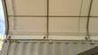 Container shelter's white PVC cover from inside, stretched over galvanized arches with ratchet tensioners at the rail