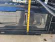 Vertical tape measure down the bucket's rear mount plate, reading about 12 inches