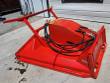 Red AGT disc mulcher at an angle, sleeved hydraulic hoses across the housing and steel push frame