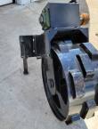 Green pillow-block bearing bolted under the compaction wheel's steel housing, park stand alongside