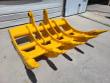 Yellow TOFT10R rake at an angle: five tines with bolted tooth tips, cross tubes and twin mounting lugs