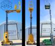 Three vertical mast lifts with masts fully raised and platforms up, two yellow units and a green Genie GR-20
