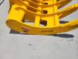 CAT336 marking and red TOFT badge on the edge of the yellow excavator rake, curved tines behind