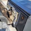 Wolverine box broom coupled to a skid steer quick-attach plate, brand decal on the black hood