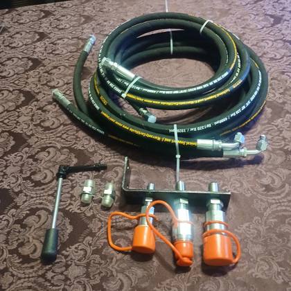 Auxiliary hydraulic kit: coiled hoses, three-coupler bracket with orange caps, control lever and adapters