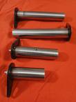 Four polished 4140 hardened steel machine pins with black retainer flags, two with grease fittings