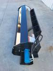 Full-length black Mower King skid steer tiller, rotor housing and adjustable skids, blue hydraulic drive motor at one end