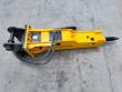 Yellow TOFT750 hydraulic breaker, black mounting bracket, hydraulic hoses and moil chisel fitted