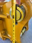 Tape measure spanning the breaker's mounting bracket pin bores, reading about 13 inches