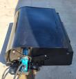 Black box broom sweeper on its back frame, blue hydraulic motor and bolted drive linkage under the hood