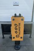 AGROTK 680 hydraulic post driver, yellow housing mounted on a skid steer quick-attach frame