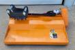 Orange flail mower with black excavator mount bracket, hydraulic motor and warning decal on the deck