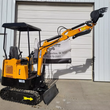 Yellow MIVA VA15 mini excavator in side profile, boom and bucket extended, canopy over the seat, backfill blade down