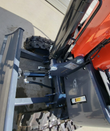 MX15R mini excavator dozer blade linkage with hydraulic cylinder and hoses above the rubber tracks