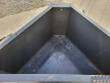 Inside the concrete bucket: sloped steel walls funneling down toward the discharge opening