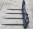 JCT hay bale spear with four spikes, skid steer quick-attach plate