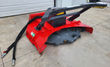 Raytree RMDM70 disc mulcher, red housing with cutting-teeth disc and coiled hydraulic hoses