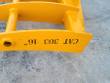 Yellow rake's outer tine bar stamped CAT 303 46 inch, tubular cross-brace and tine socket alongside
