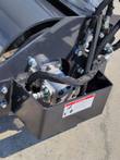 Vibratory roller end drive: hydraulic motor bolted inside the guard box, braided hoses and a DANGER decal