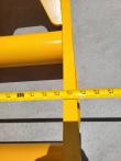 Tape measure laid across the yellow rake's frame width, reading in the 60-inch range