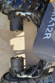 Both travel hydraulic motors under the AGT MX12R mini excavator, with wrapped hoses running to the rubber tracks