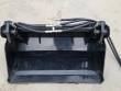 Black 4-in-1 skid steer bucket head-on: clamshell jaw, cylinder and braided hydraulic hoses across the top